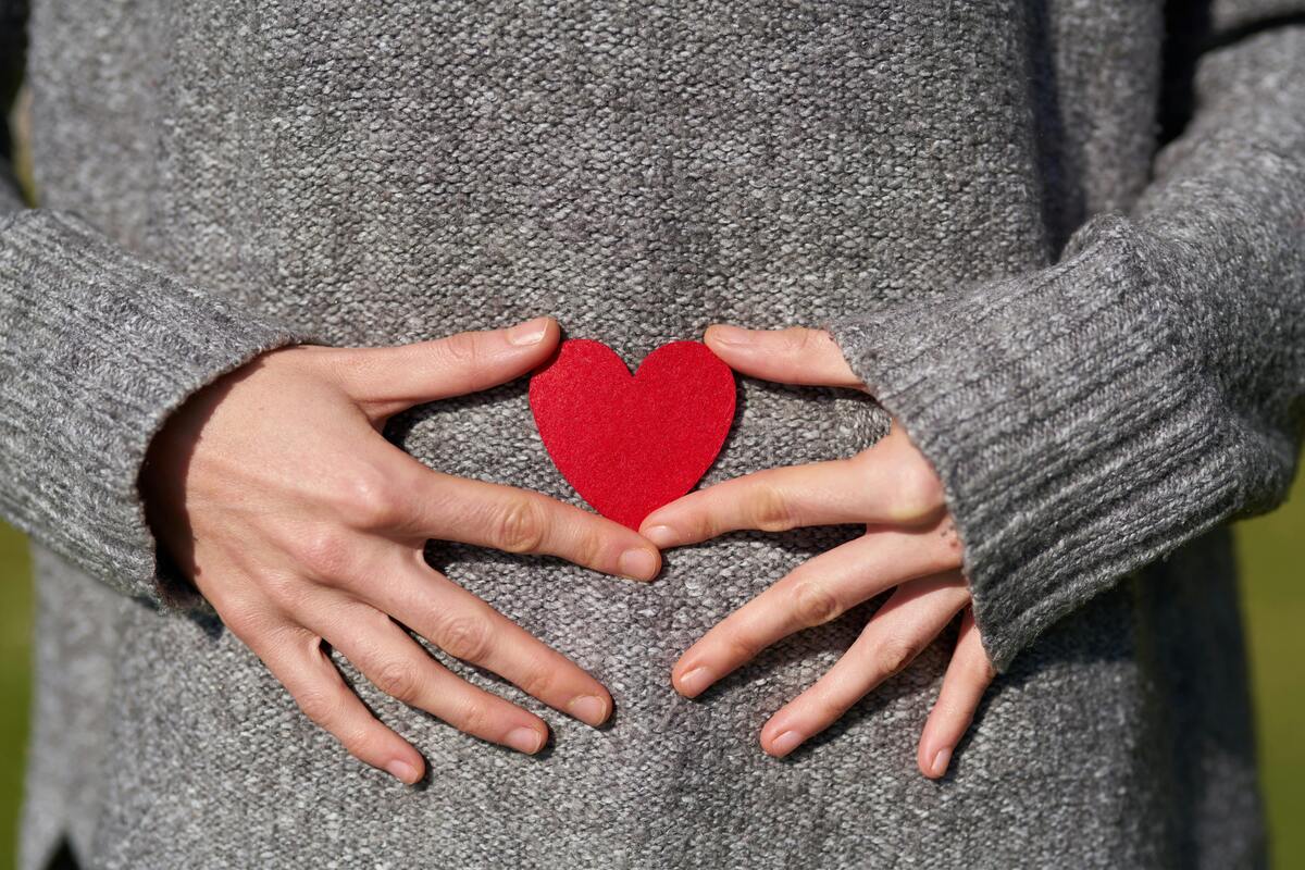 woman's hands holding a red heart